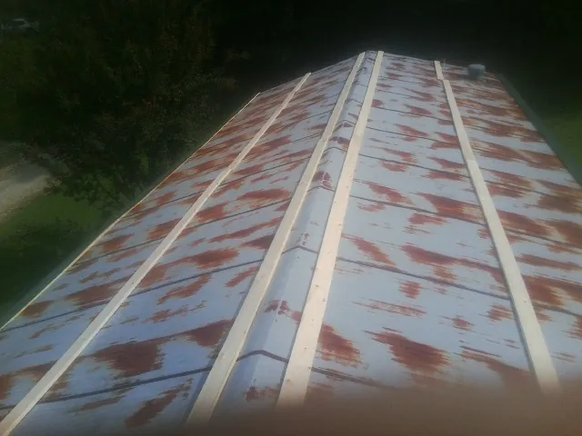 Rusted metal roof panels with new wood purlins before replacement — Storm Damage Roof Repair in Rossville by Roofing Brothers